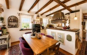 a kitchen with a wooden table and purple chairs at Villa Novel in Višnjan