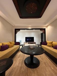 a living room with two couches and a table at Man Wee Apprt in Tangier