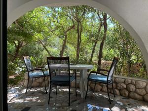 a table and chairs on a patio with trees at Apartments MiaMaja 2 in Novalja