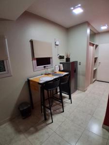 a kitchen with a table and a counter with a sink at Dos Lapachos in San Fernando del Valle de Catamarca