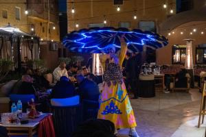 a woman in a colorful dress holding an umbrella at Le Pacha Pyramids Hotel in Cairo