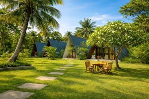 a resort with a table and chairs in the grass at Marina Safari Resort Udawalawe in Udawalawe