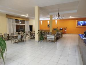 a lobby with tables and chairs and a restaurant at Hotel Don Oresttes in La Carrera