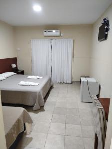 a hotel room with two beds and a window at Hotel Don Oresttes in La Carrera
