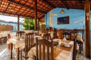 a restaurant with tables and chairs in a room at Pousada Universo Arraial in Arraial d'Ajuda