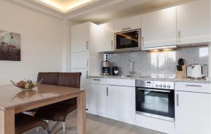a kitchen with white cabinets and a wooden table at Princess in Binz