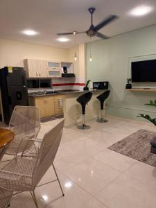 ein Wohnzimmer mit Stühlen und eine Küche mit Deckenventilator in der Unterkunft Oasis Olmos in Cereté