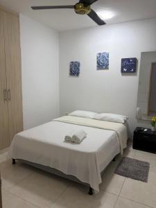 ein Schlafzimmer mit einem Bett, auf dem zwei Handtücher liegen in der Unterkunft Oasis Olmos in Cereté
