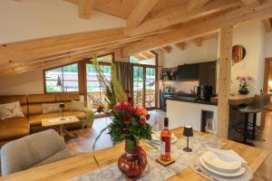 a kitchen and living room with a table with flowers at Haus Hochlenzerblick in Schönau am Königssee