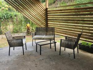 three chairs and a table in front of a fence at Kelinda in Les Abymes