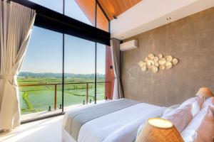 a bedroom with a bed and a large window at Duality Villas in Ubud +25 photos