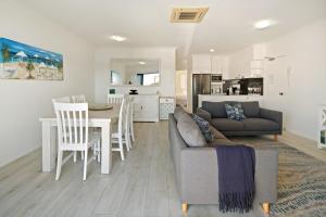 a living room with a couch and a table and chairs at Riverfront 2BR Apt with Views, Balcony & Parking in Maroochydore