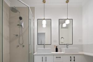a bathroom with two sinks and a shower with two mirrors at Riverfront 2BR Apt with Views, Balcony & Parking in Maroochydore +13 photos