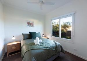 a bedroom with a bed and a window at The Gums - Echuca Holiday Homes in Echuca
