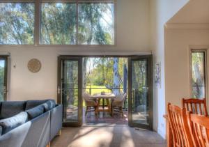 a living room with a couch and a table at The Gums - Echuca Holiday Homes in Echuca
