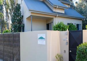 a white house with a fence and a gate at The Gums - Echuca Holiday Homes in Echuca +13 photos