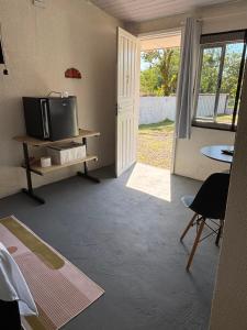 a living room with a tv and a table and a door at Cantinho da Nonna in Morretes