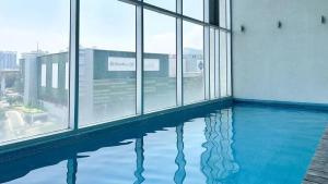 an empty swimming pool in a building with windows at QBICo Santa Fe Condominium in Mexico City