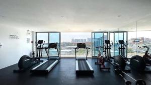 a gym with several tread machines in a room with windows at QBICo Santa Fe Condominium in Mexico City