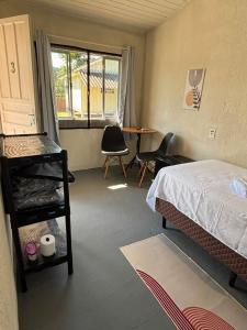 a bedroom with a bed and a table and chairs at Cantinho da Nonna in Morretes