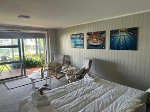 a bedroom with a bed and a table and chairs at The Pacific Room, Tapeka Point in Russell