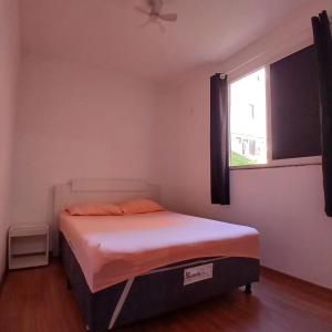 a small bedroom with a bed with a window at Apartamento Harmonia! in Uberaba +9 photos