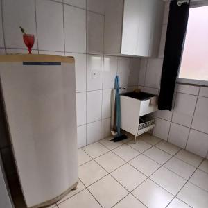 a small kitchen with a refrigerator and a window at Apartamento Harmonia! in Uberaba