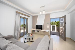 a living room with a couch and a tv at Villa Vatia 2 in Tragaki