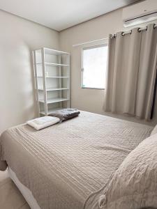 a bedroom with a large bed and a window at Casa parque 18 in Araguaína