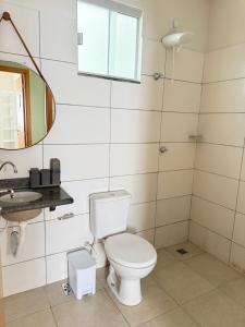a bathroom with a toilet and a sink and a mirror at Casa parque 18 in Araguaína +15 photos