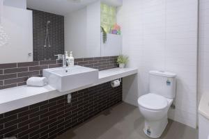 a bathroom with a white sink and a toilet at Bay View - Green Vista in Lorne +13 photos