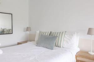 a bedroom with a white bed with two lamps at Bay View - Green Vista in Lorne