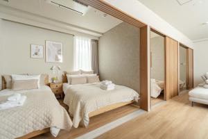 a bedroom with two beds and a mirror at SoMA Kagurazaka in Tokyo