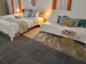a living room with two beds and a table at Terakota lodge in Deshaies