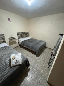 a bedroom with two beds and a tv in it at Hotel Casa de Los Abuelos in Bernal
