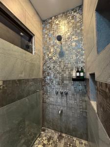 a bathroom with a shower with a tile wall at La Casona in Fortuna +115 photos