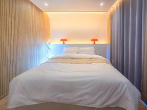 a bedroom with a white bed with two lights on it at 담양 다움 스파 빌리지 in Haktong-ni +28 photos