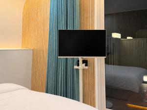 a flat screen tv on a wall next to a bed at 담양 다움 스파 빌리지 in Haktong-ni