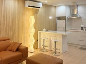 a living room with a couch and a kitchen at 담양 다움 스파 빌리지 in Haktong-ni