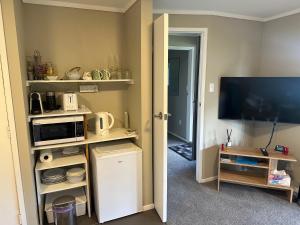 a room with a kitchen with a tv and a microwave at The Pacific Room, Tapeka Point in Russell +13 photos
