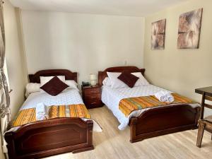 two beds sitting next to each other in a bedroom at HOTEL en el CENTRO HISTORICO in Cuenca