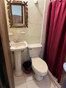 a bathroom with a toilet and a sink and a mirror at Hotel Casa de Los Abuelos in Bernal