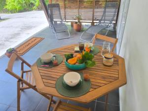 a wooden table with a bowl of fruit on it at Terakota lodge in Deshaies