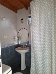 a bathroom with a sink and a shower curtain at Alojamiento temporario 2 in Lanús +20 photos