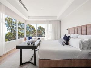 a bedroom with a large bed and a table at Eagle Heights - Elevated Oasis with Pool & Sea Views in Dunsborough
