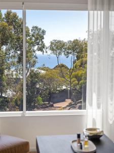 a room with a large window with a view of trees at Eagle Heights - Elevated Oasis with Pool & Sea Views in Dunsborough