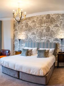 a bedroom with a large bed with a stone wall at The High Field Town House in Birmingham