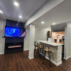 a kitchen with a bar with a fireplace and a tv at beautiful private house in Edmonton