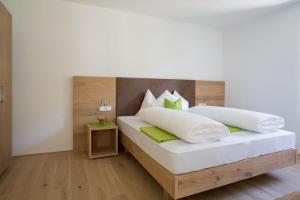a bedroom with a bed with white and green pillows at Ferienwohnungen Hochbrunner in Terlano