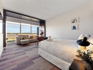 a bedroom with a large bed and a living room at Samphire Chalet Tuart - Luxury Amidst Nature in Geographe